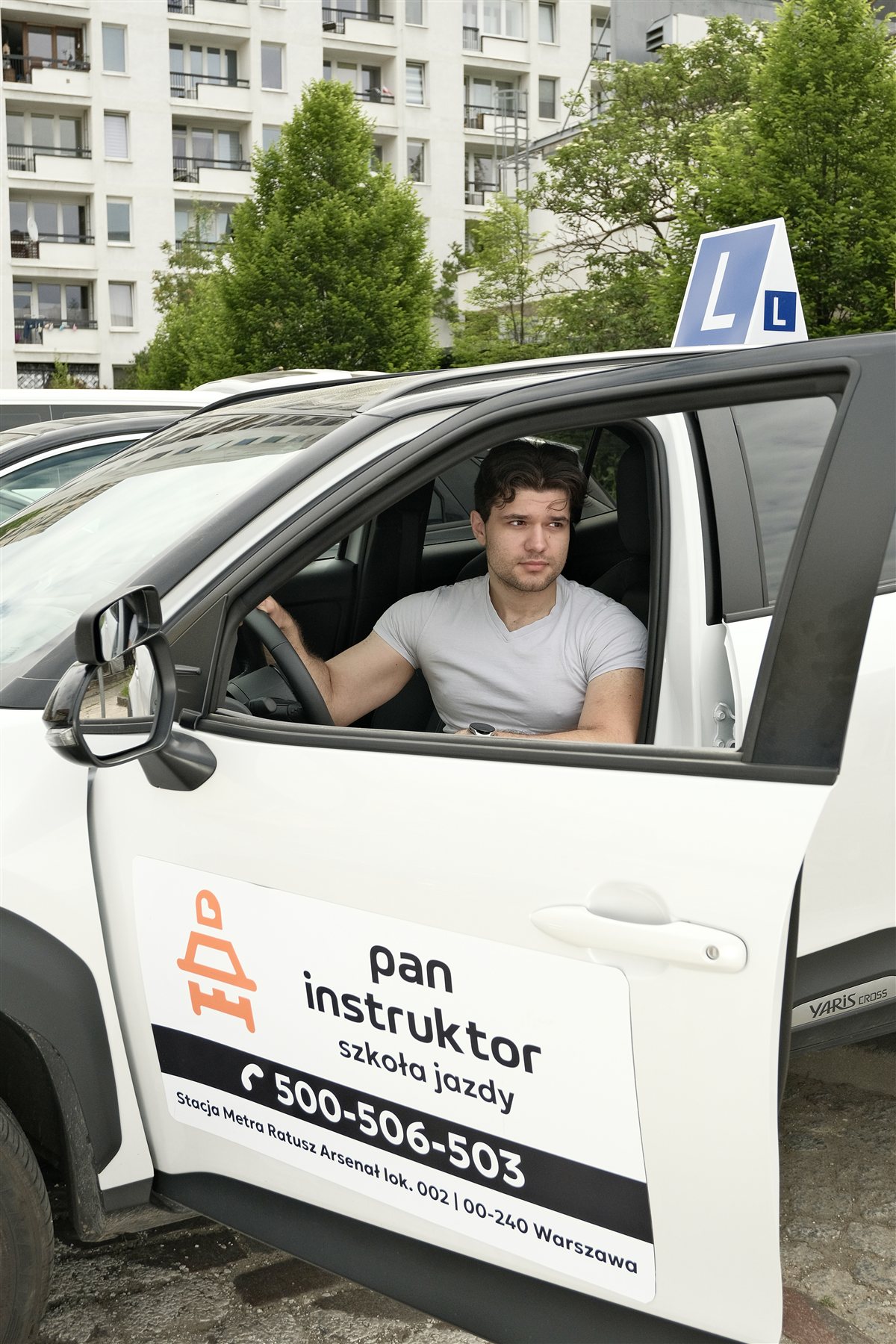 Kursant szkoły jazdy Pan Instruktor w samochodzie z logo — Warszawa